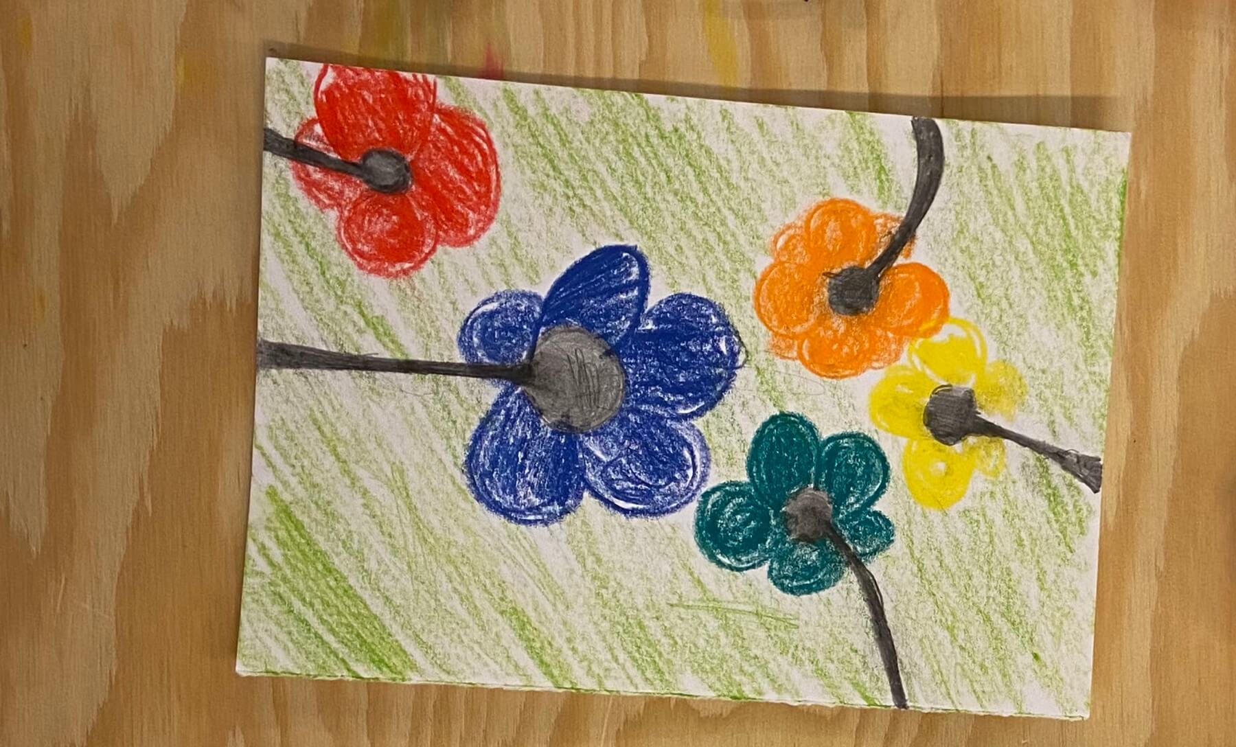 Zeichnung: Fünf bunte Blumen mit Stängeln (gemalt mit Bleistift), die bis an den Bildrand gehen