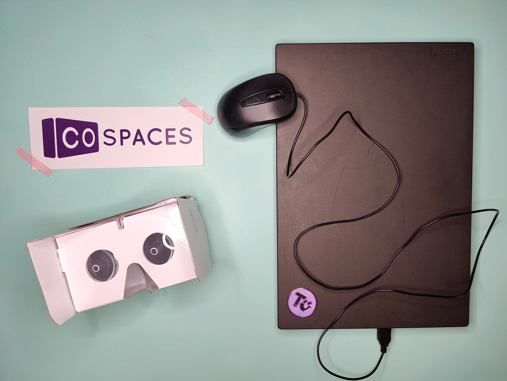 Ein Laptop mit Maus, eine Cardboard-VR-Brille, das Logo von CoSpaces