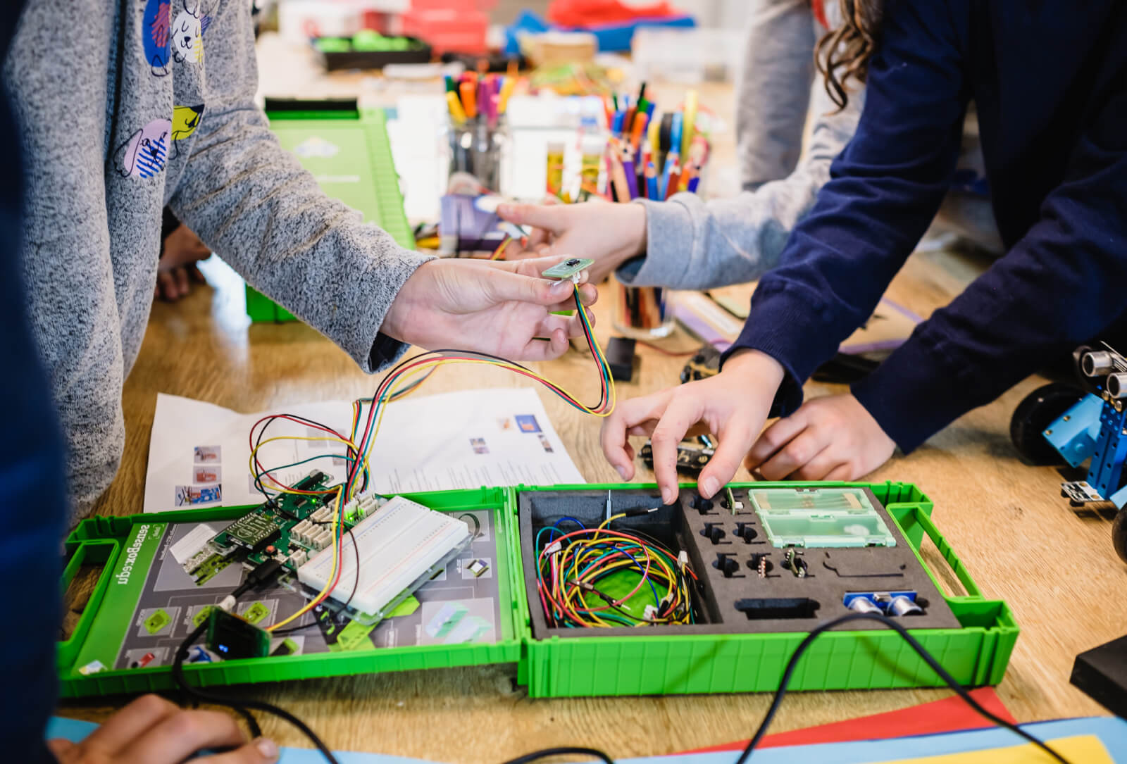 Eine offene senseBox, drei Kinder hantieren mit der senseBox