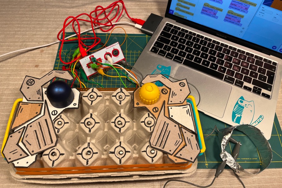Eine gebastelte Klamaschine ist durch ein Makey Makey mit einem Laptop verbunden.