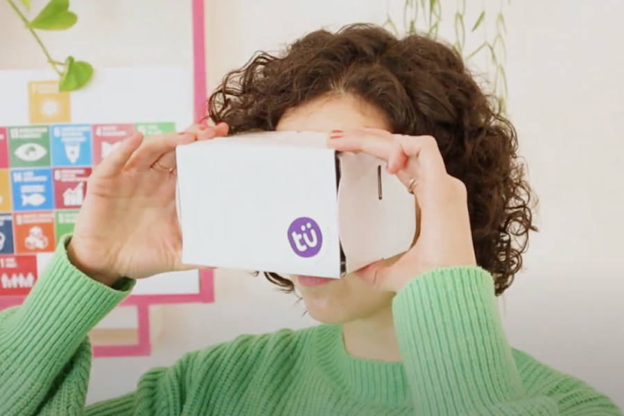 Frau blickt in eine aus Papier gebastelte VR-Brille