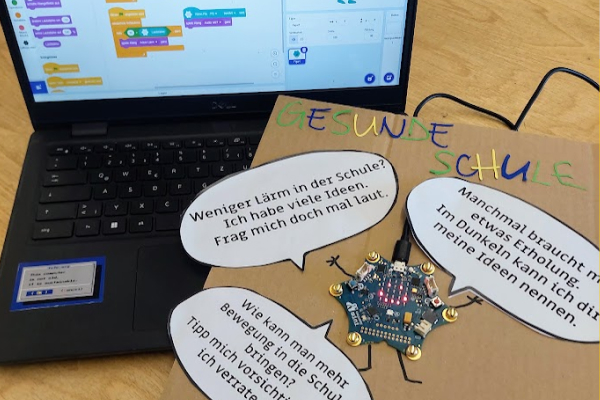 Ein Poster mit dem Titel „Gesunde Schule", auf dem Poster klebt ein Calliope. Der Calliope ist mit einem Computer verbunden.