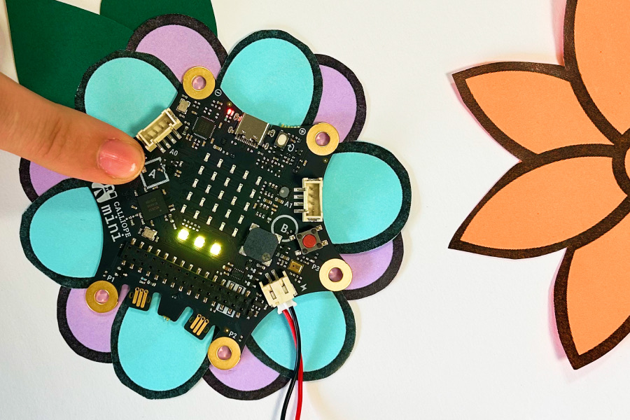 Ein Calliope aufgeklebt auf einer gebastelten Blume. Auf dem Calliope leuchten drei Lämpchen