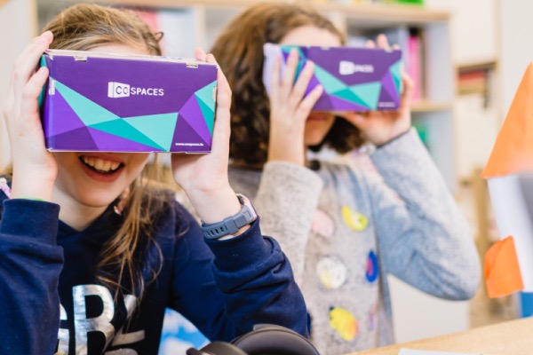 Zwei Kinder halten jeweils eine VR-Brille vor ihr Gesicht
