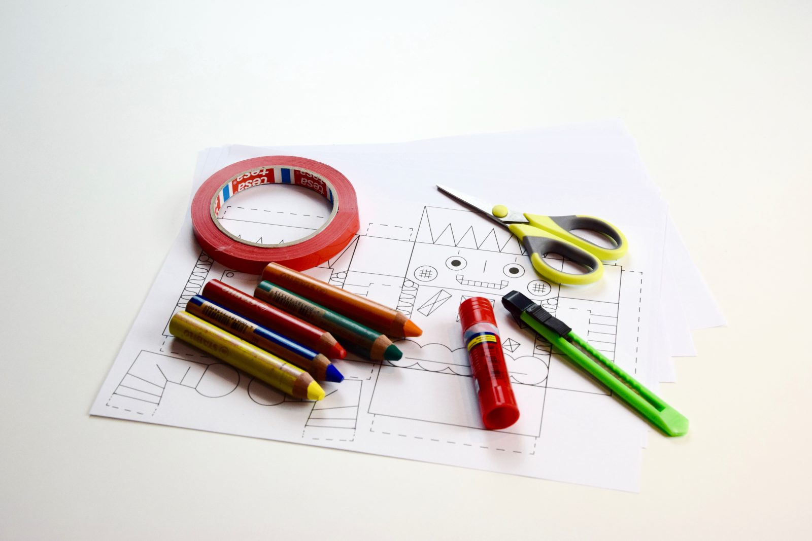 Roboter-Vorlage, Klebestift, ein paar Buntstifte, Cutter, Schere, Klebeband